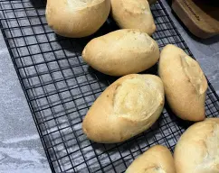Step <p>Saque los bollitos del horno y precaliente el horno a 200º. Pulverice sobre los panecillos agua y un poco de aceite. Hornee durante 20 minutos. Deje enfriar en una rejilla y ¡listos para degustar!</p> illustration