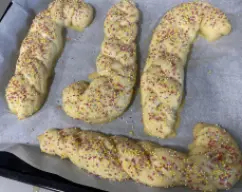 Step <p>Precaliente el horno a 200 y mientras tanto vaya pincelando los gaiatos con huevo batido y espolvoree por encima las bolitas de colores. </p> illustration