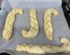 Step <p>Coloque los gaiatos en la bandeja de horno preparada y déjelos reposar hasta que doblen su volumen en un lugar templado y libre de corrientes de aire aproximadamente dos horas.</p> illustration